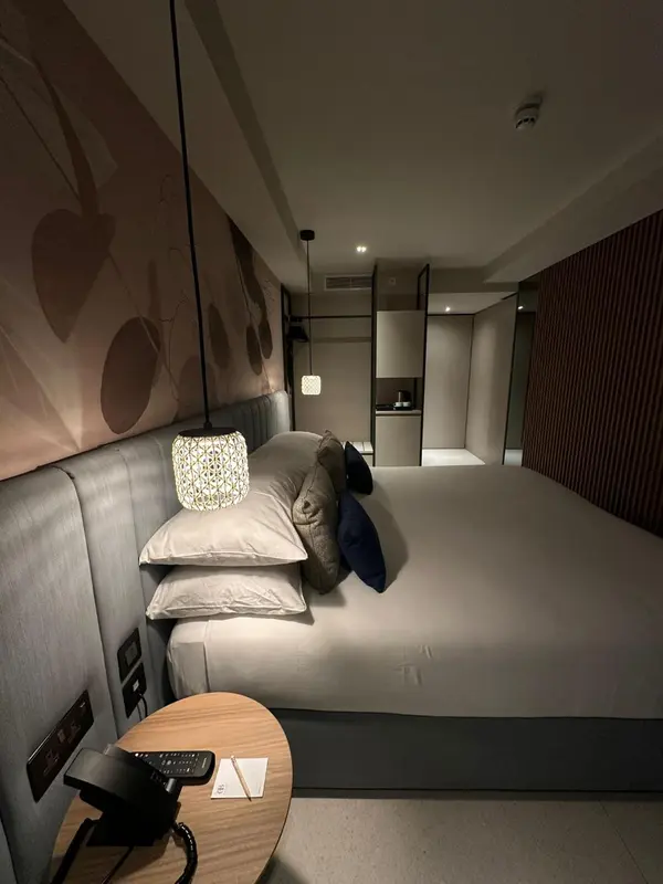 Une chambre d'hôtel moderne avec un lit confortable et une table de chevet.