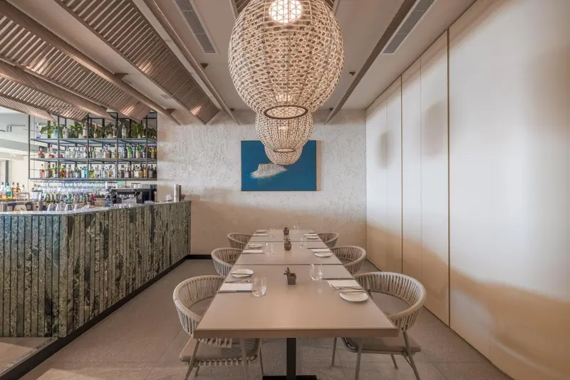 Une salle à manger lumineuse avec une longue table et des chaises design.