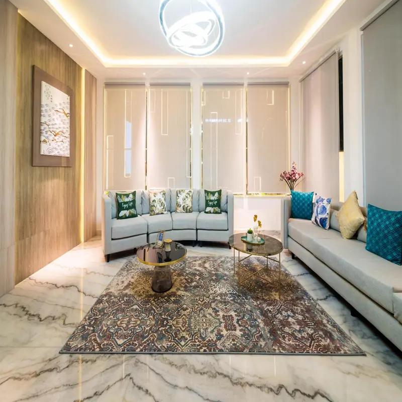 Un salon clair et moderne avec un canapé d'angle et un tapis décoratif.