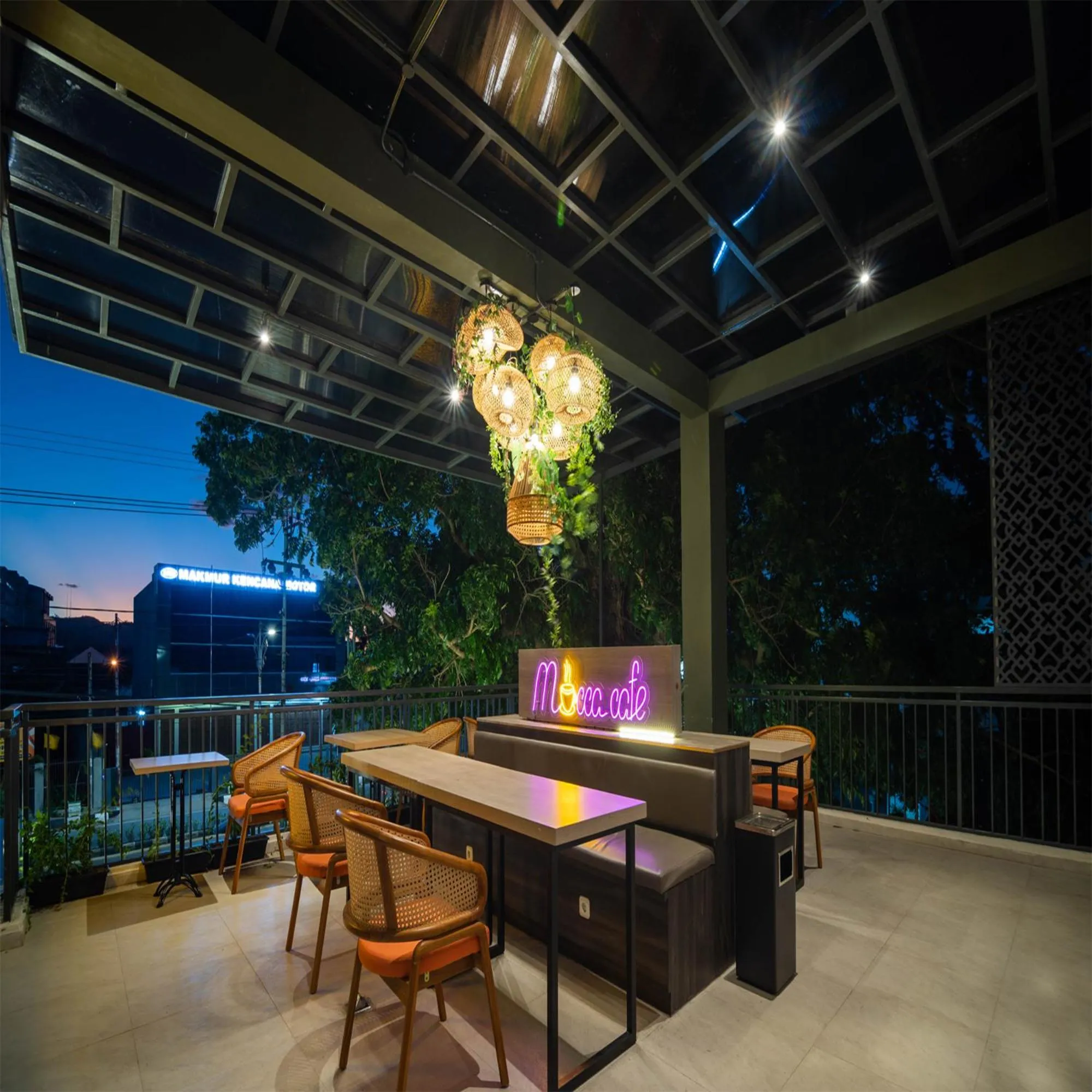 Terrasse avec tables et chaises sous un éclairage décoratif.