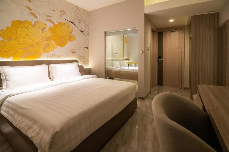 Une chambre lumineuse avec un grand lit et un mur décoratif.