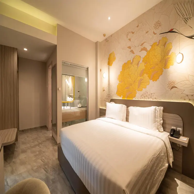 Une chambre lumineuse avec un grand lit et un décor floral.