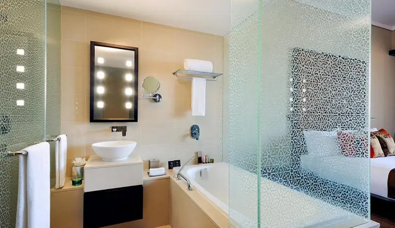 Une salle de bain moderne avec une baignoire et un grand miroir éclairé.
