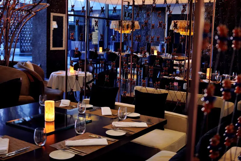 Une salle de restaurant élégante avec des tables dressées et une décoration lumineuse.
