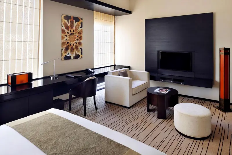 Une chambre moderne avec un bureau, un fauteuil et un lit.