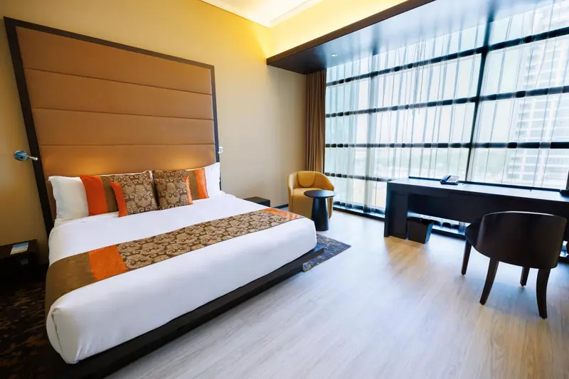 Une chambre lumineuse avec un grand lit et un espace bureau.