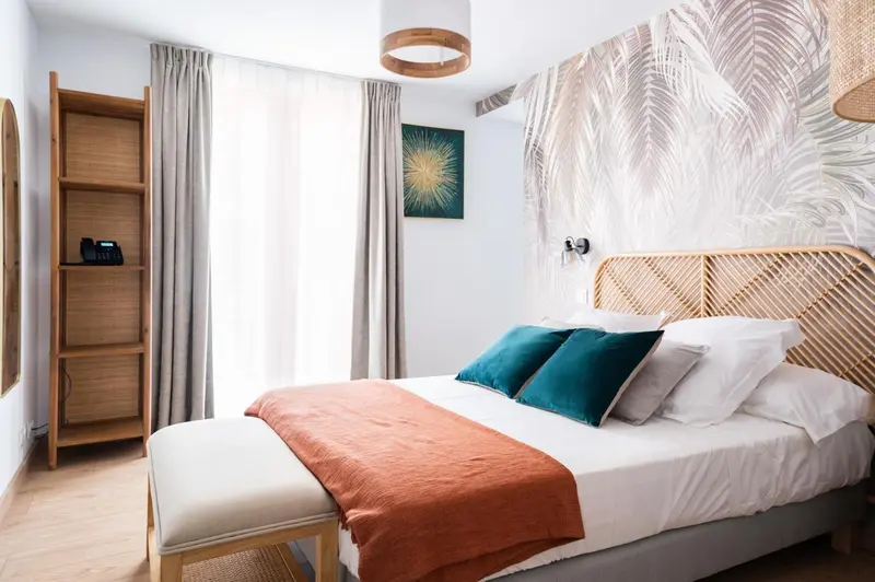 Une chambre lumineuse avec un grand lit et une décoration tropicale.