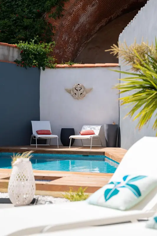 Deux chaises longues invitent à la détente au bord d'une piscine ensoleillée.