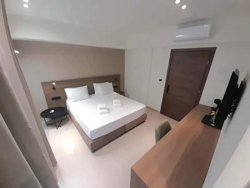 Une chambre lumineuse avec un grand lit et un accès à une salle de bain.
