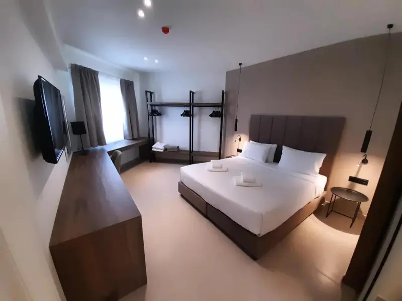 Une chambre lumineuse avec un grand lit et un espace bureau.