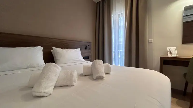 Une chambre lumineuse avec un grand lit et une décoration sobre.