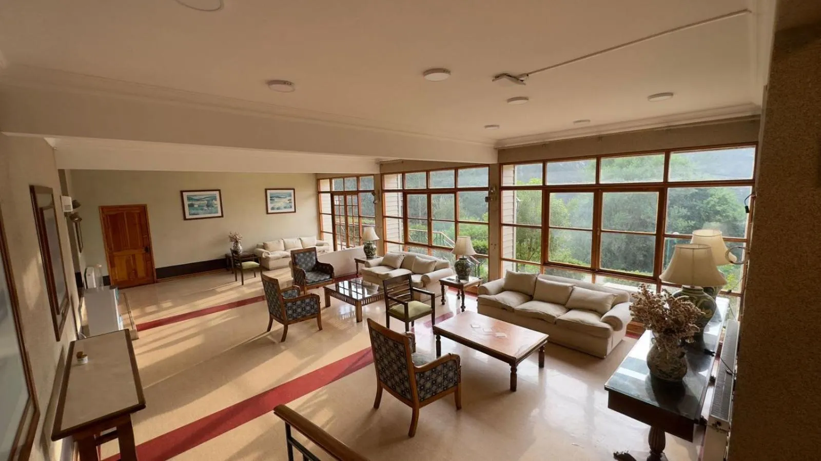 Espace de détente intérieur avec canapés et larges baies vitrées.