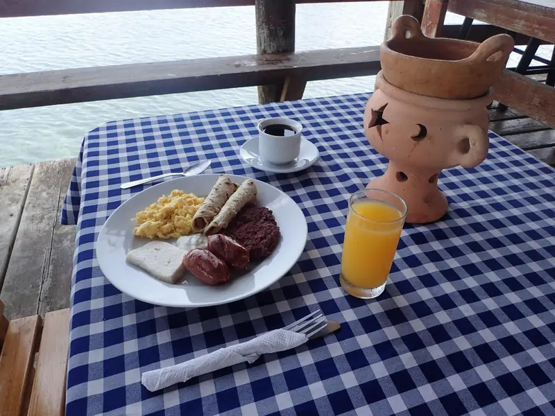 Une table dressée avec un petit-déjeuner complet en bord de mer.