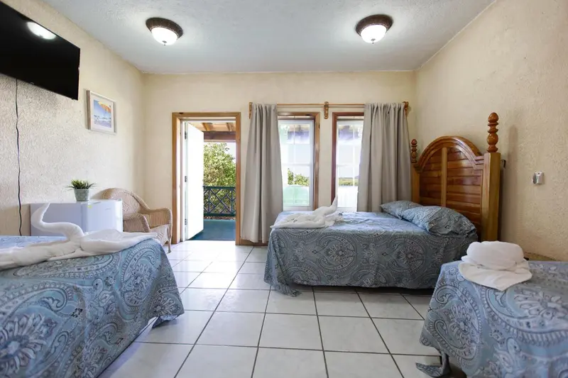 Une chambre lumineuse avec deux lits et un accès à une terrasse.