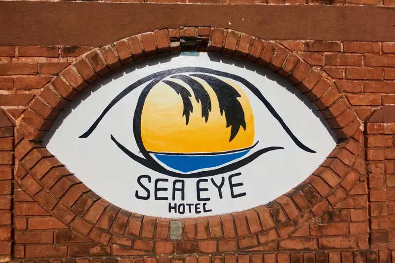 Un oeil stylisé avec un paysage marin reflété dans la pupille orne une façade en briques.