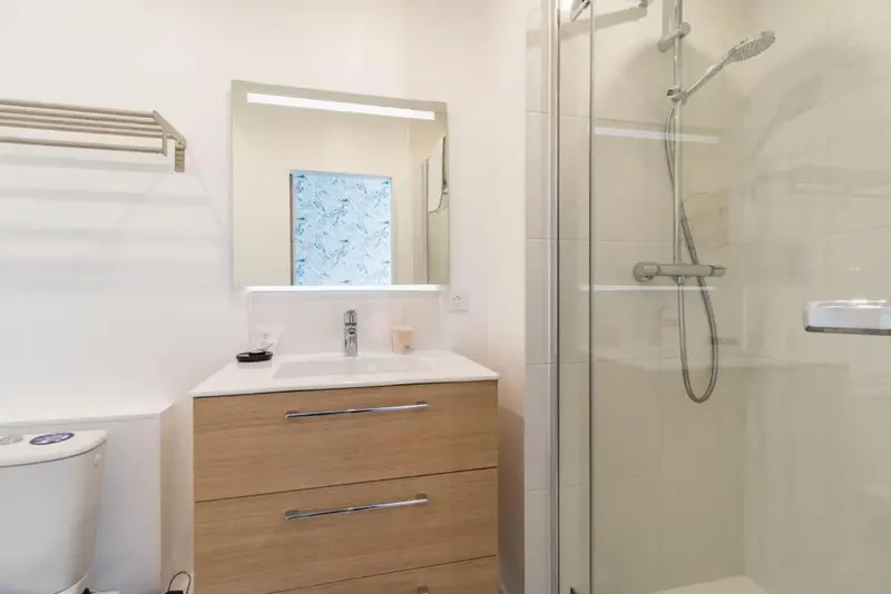 Une salle de bain moderne avec douche à l'italienne et meuble vasque.
