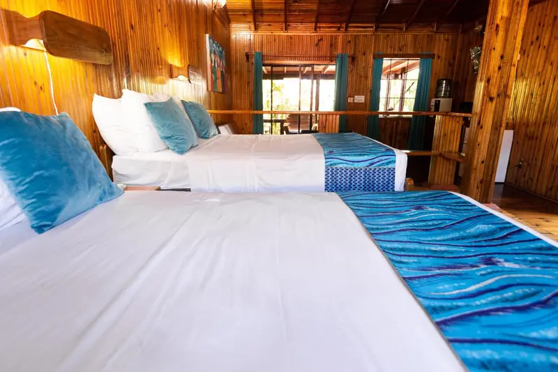 Une chambre lumineuse avec deux lits simples et une décoration turquoise.