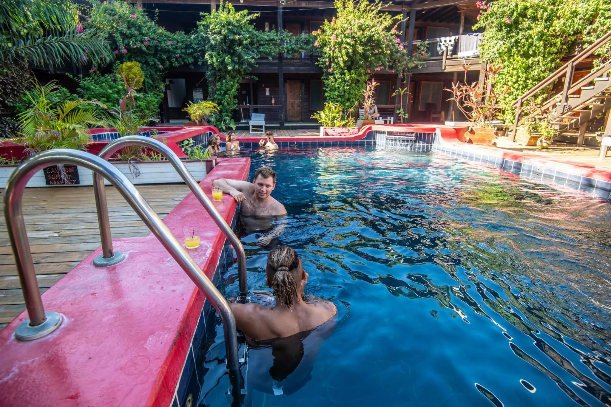 Des personnes se détendent au bord d'une piscine ensoleillée.