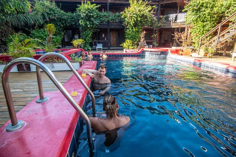 Des personnes se détendent au bord d'une piscine ensoleillée.