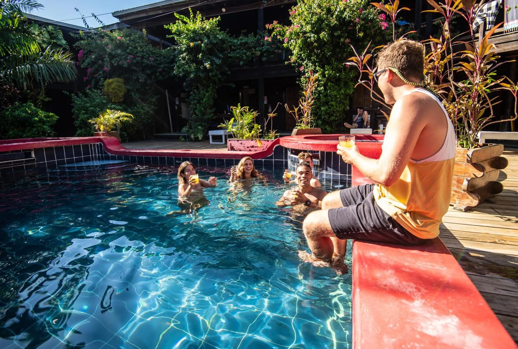 Des personnes se détendent au bord d'une piscine ensoleillée.