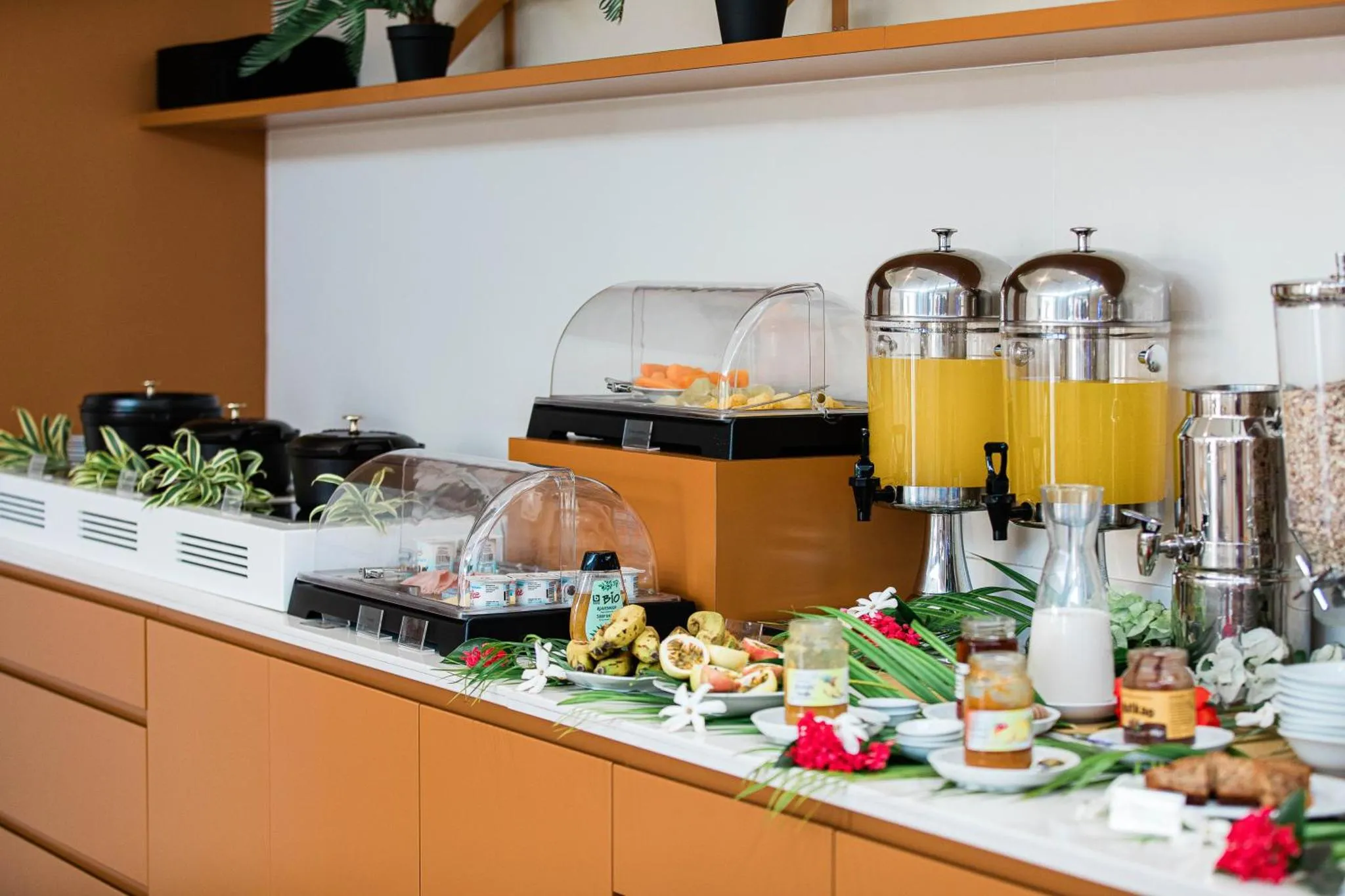 Un buffet propose des fruits, des jus et des viennoiseries.