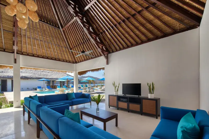 Un espace de détente intérieur avec canapés bleus et une télévision.