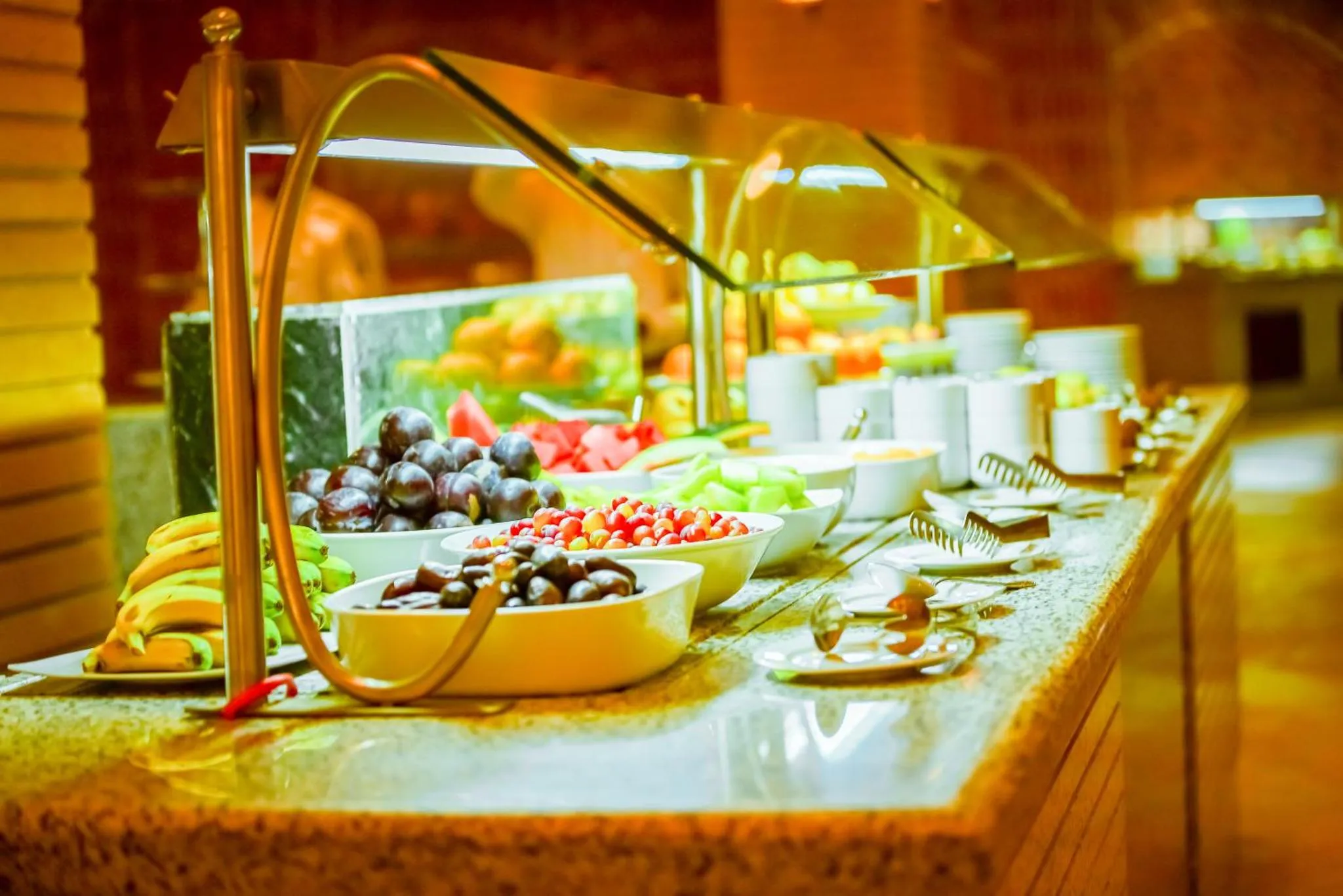 Un buffet propose une variété de fruits frais et de pâtisseries.