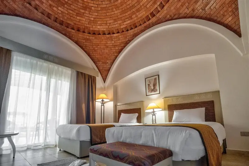 Chambre lumineuse avec deux lits simples et décoration soignée.