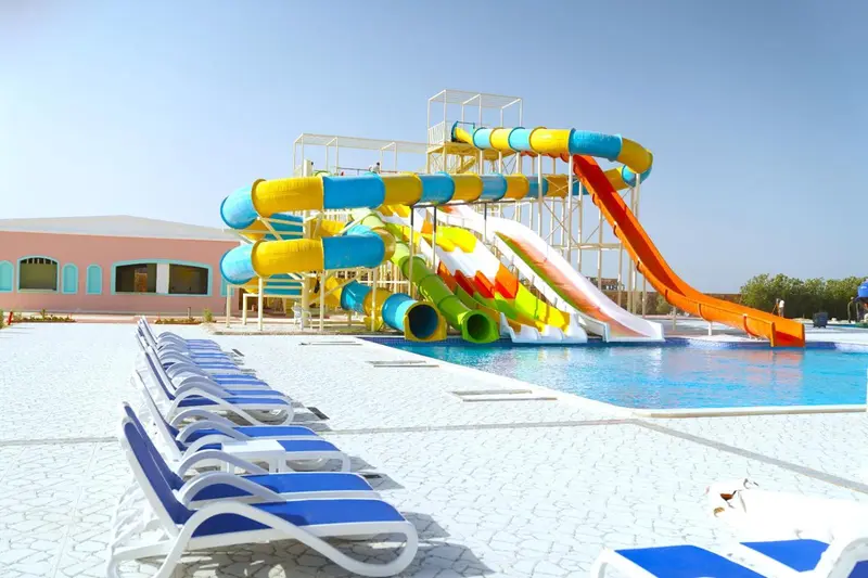 Toboggans aquatiques colorés surplombant une piscine ensoleillée.