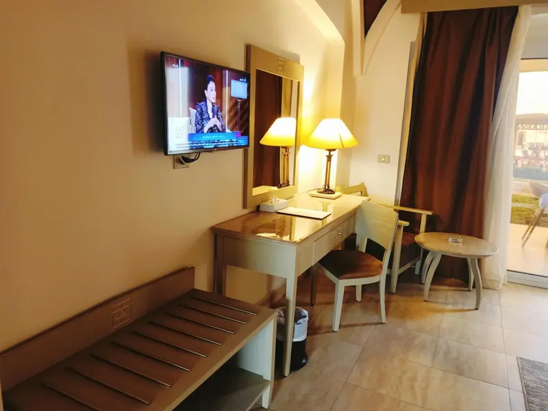 Une chambre lumineuse avec un bureau et une télévision murale.
