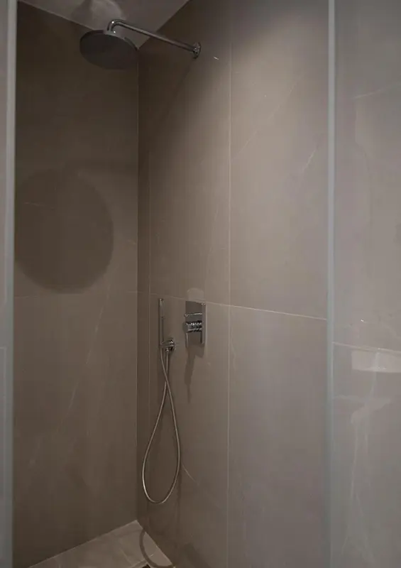 Une douche à l'italienne moderne avec des carreaux gris.