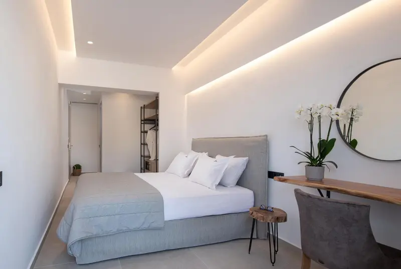 Une chambre lumineuse avec un grand lit et un espace bureau.