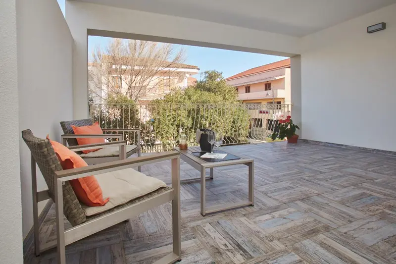 Terrasse aménagée avec mobilier de jardin et vue sur la végétation.