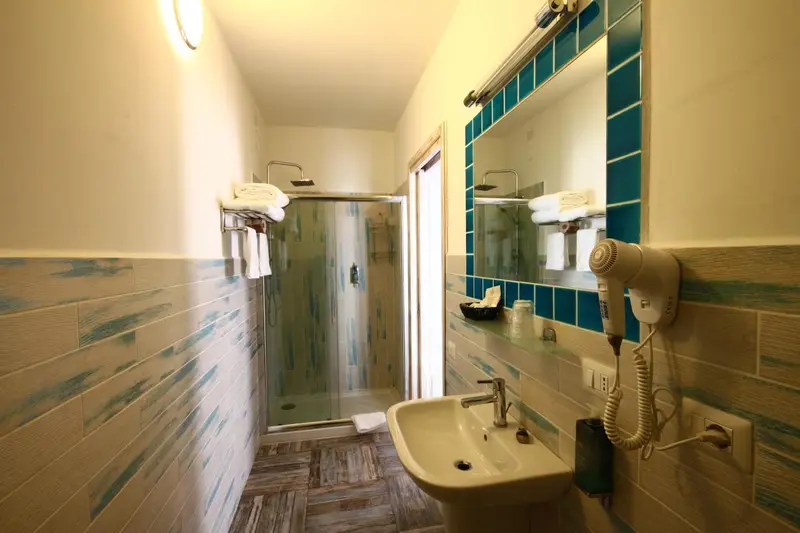 Une salle de bain claire avec douche et lavabo.