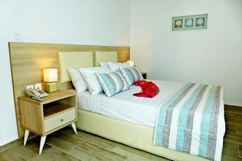 Une chambre lumineuse avec un grand lit recouvert d'une courtepointe.