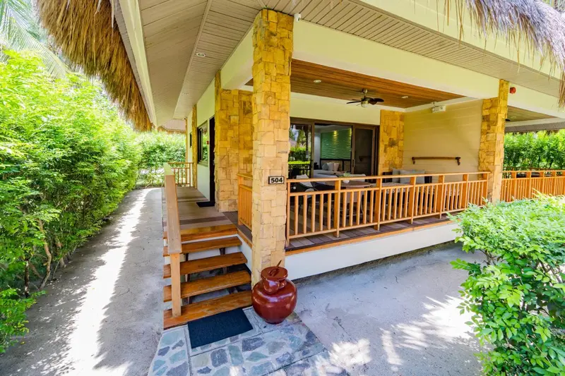 Terrasse en bois avec mobilier de jardin devant une porte vitrée.