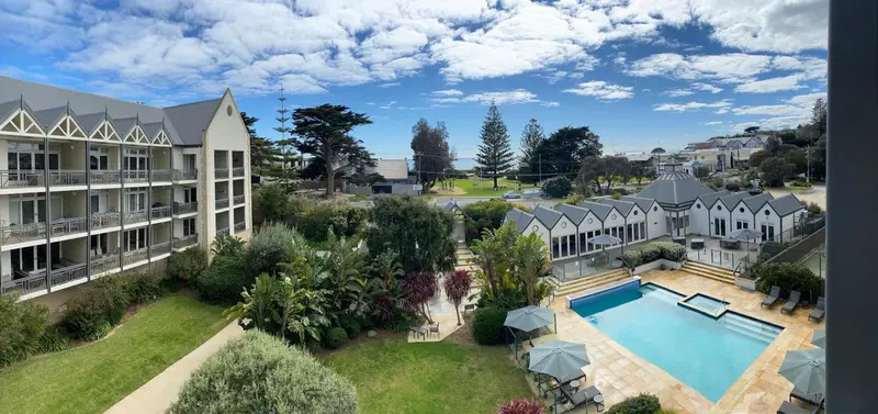Vue aérienne d'un complexe hôtelier avec piscine et végétation luxuriante.