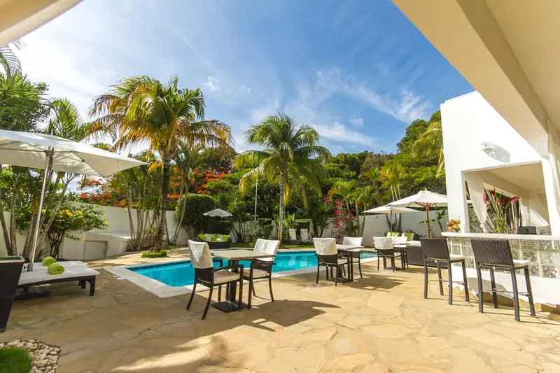 Terrasse avec mobilier de jardin et piscine ensoleillée.