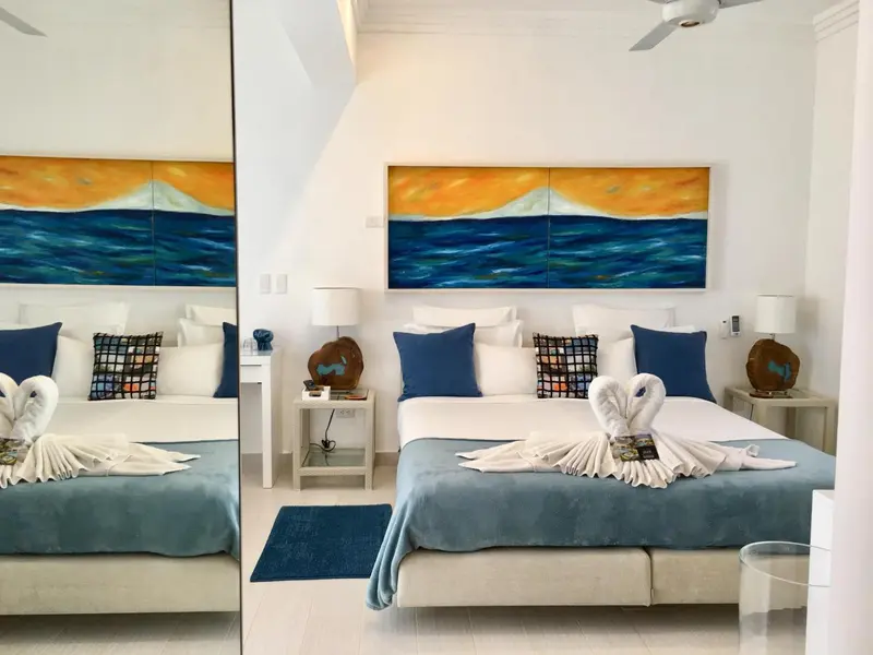 Une chambre lumineuse avec un grand lit et une décoration marine.