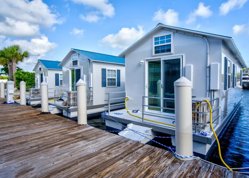 Maisons flottantes amarrées sur un ponton au bord de l'eau.
