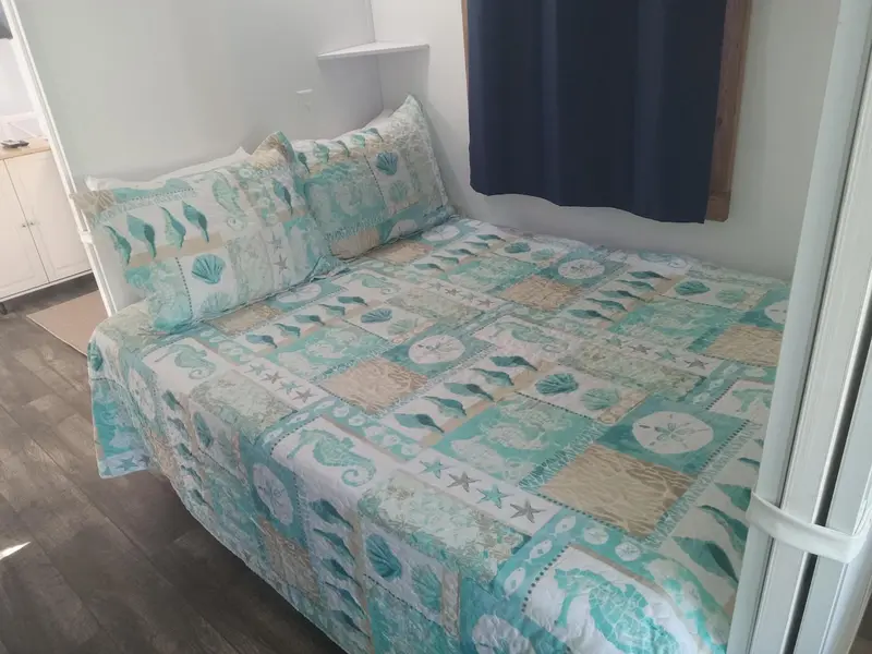 Un lit recouvert d'une courtepointe à motifs marins dans une chambre.