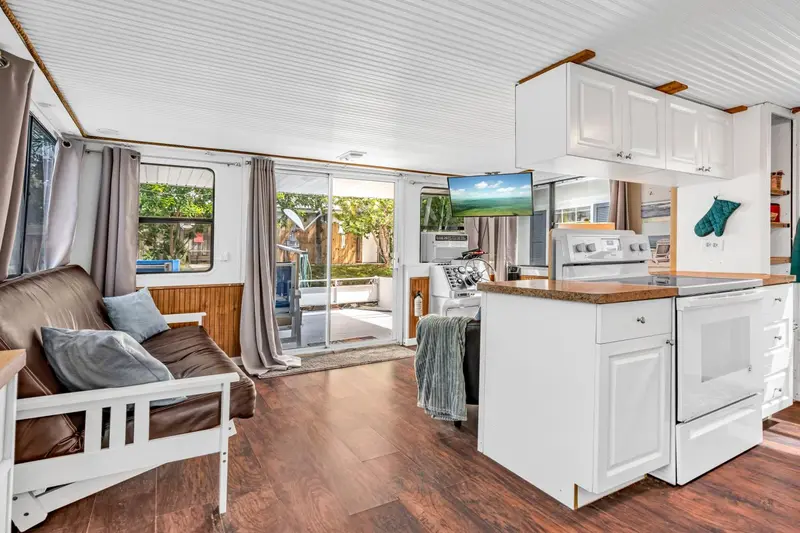 Interieur lumineux avec coin salon et cuisine ouverte donnant sur l'exterieur.