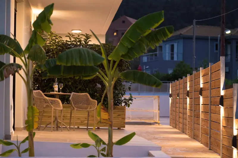 Terrasse lumineuse avec mobilier de jardin et plantes tropicales.