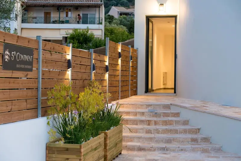 Entree d'un residence avec un jardin et un escalier en pierre.
