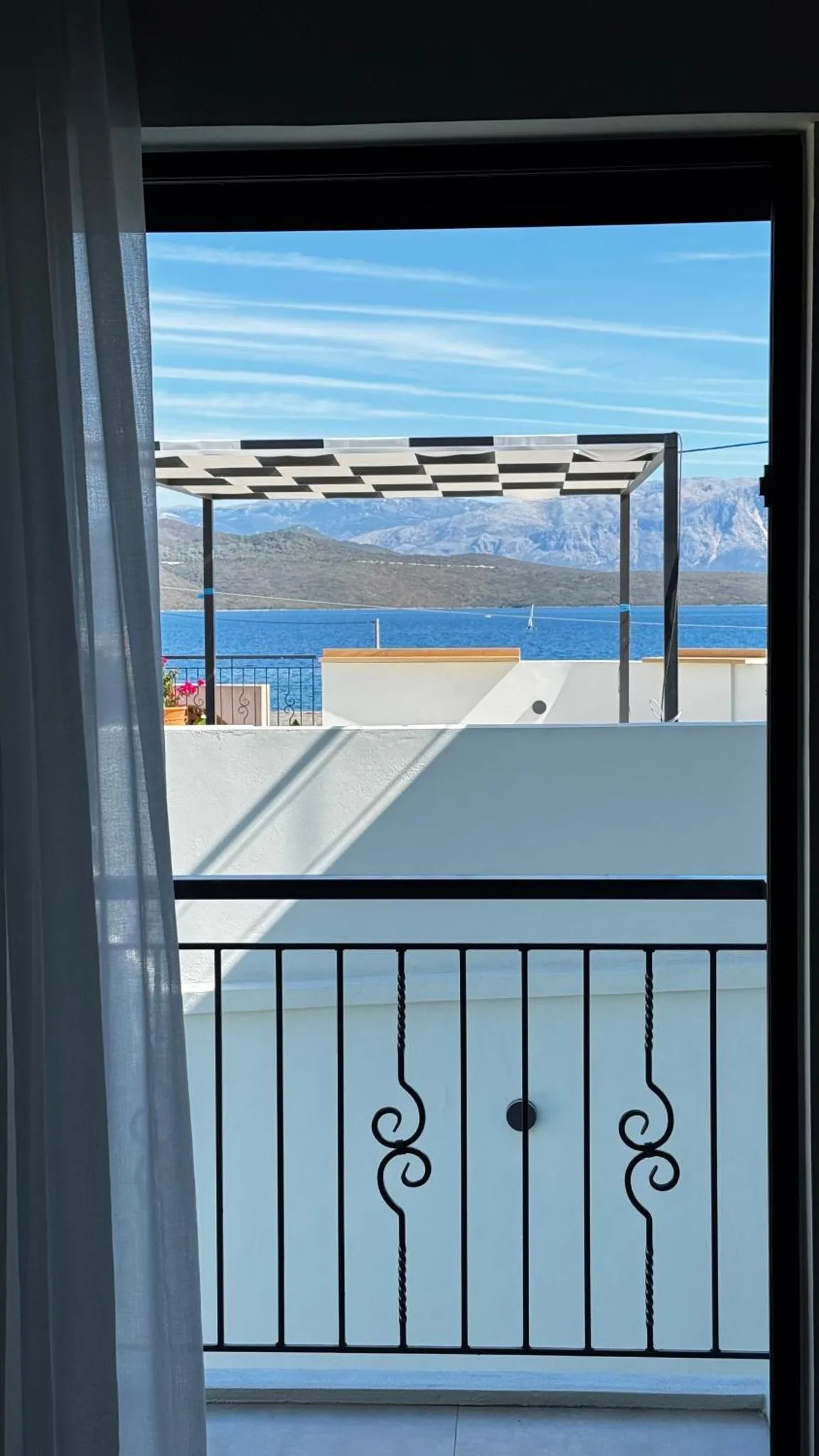 Vue sur la mer depuis un balcon avec garde-corps en fer forgé.