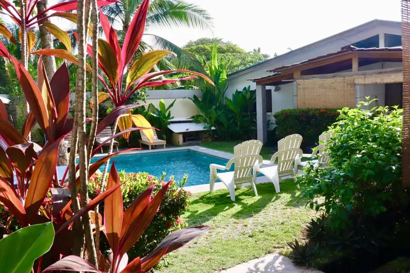 Espace de détente avec chaises longues autour d'une piscine ensoleillée.