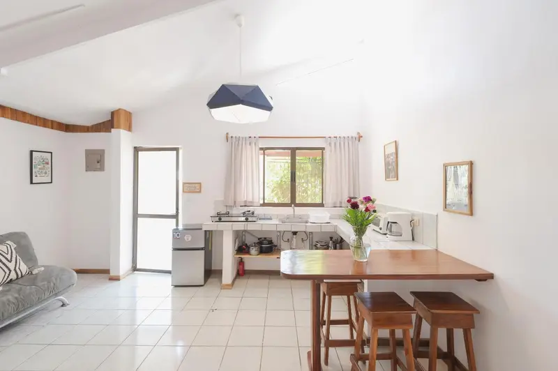 Interieur lumineux avec coin repas et cuisine ouverte.