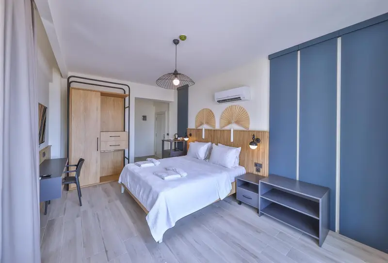 Une chambre lumineuse avec un grand lit et un bureau.