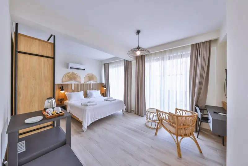 Une chambre lumineuse avec un grand lit et un coin salon.