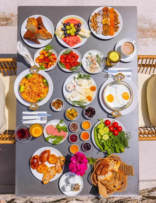 Table garnie de divers plats pour un copieux petit-déjeuner.